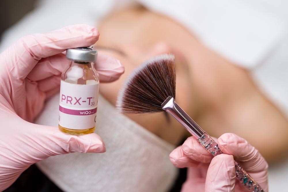 Närbild av PRX-T33 ampull och sminkborste inför kemisk peeling ansiktsbehandling